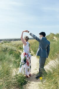Newlyweds dancing in the sand dunes